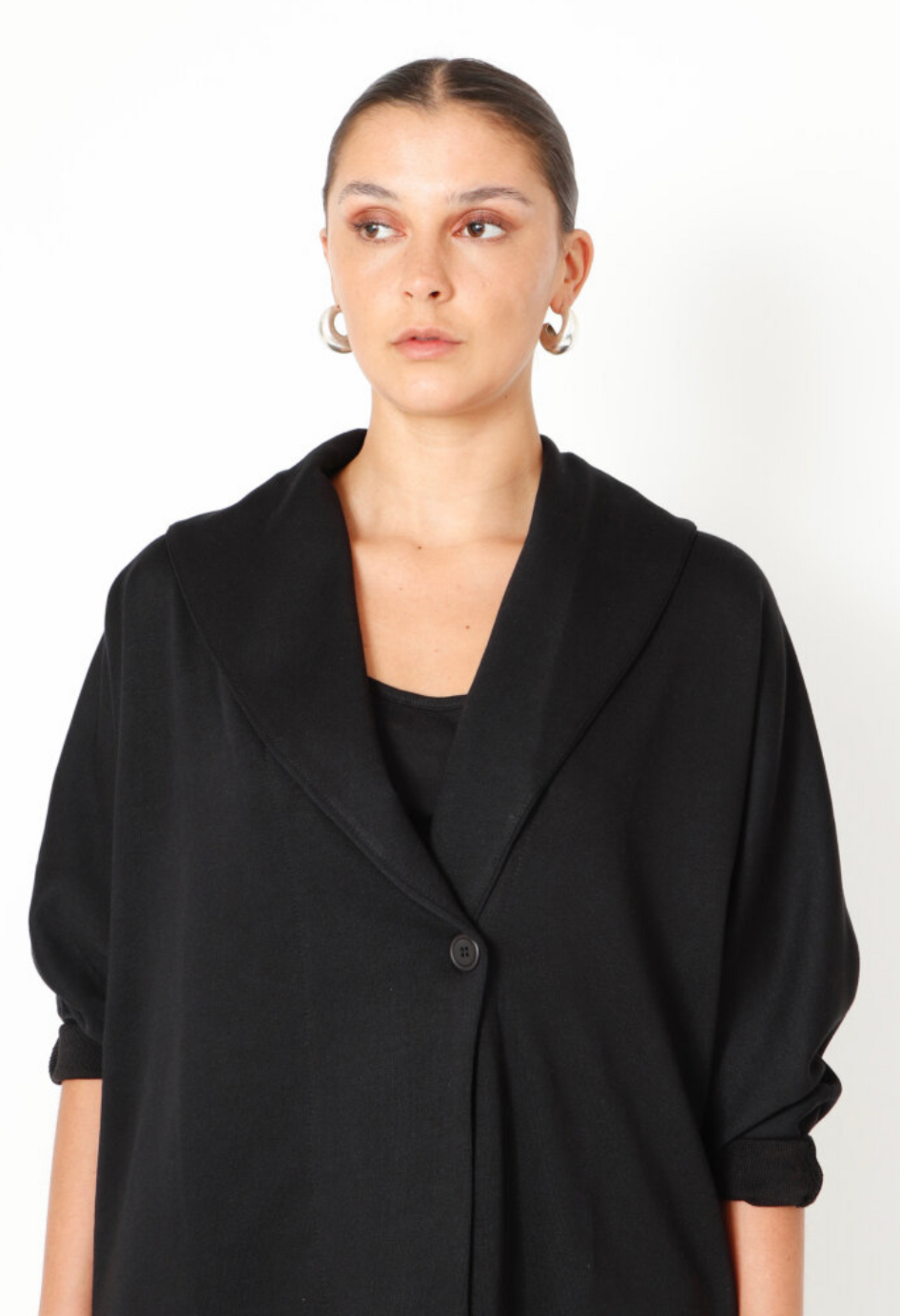 Women's boxy cardigan with a relaxed fit, button closure, and a casual collar. Made in a French Terry fabric. In colour black by Sort Aarhus. Close up view.