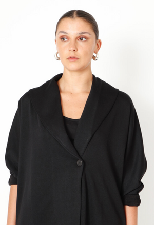 Women's boxy cardigan with a relaxed fit, button closure, and a casual collar. Made in a French Terry fabric. In colour black by Sort Aarhus. Close up view.