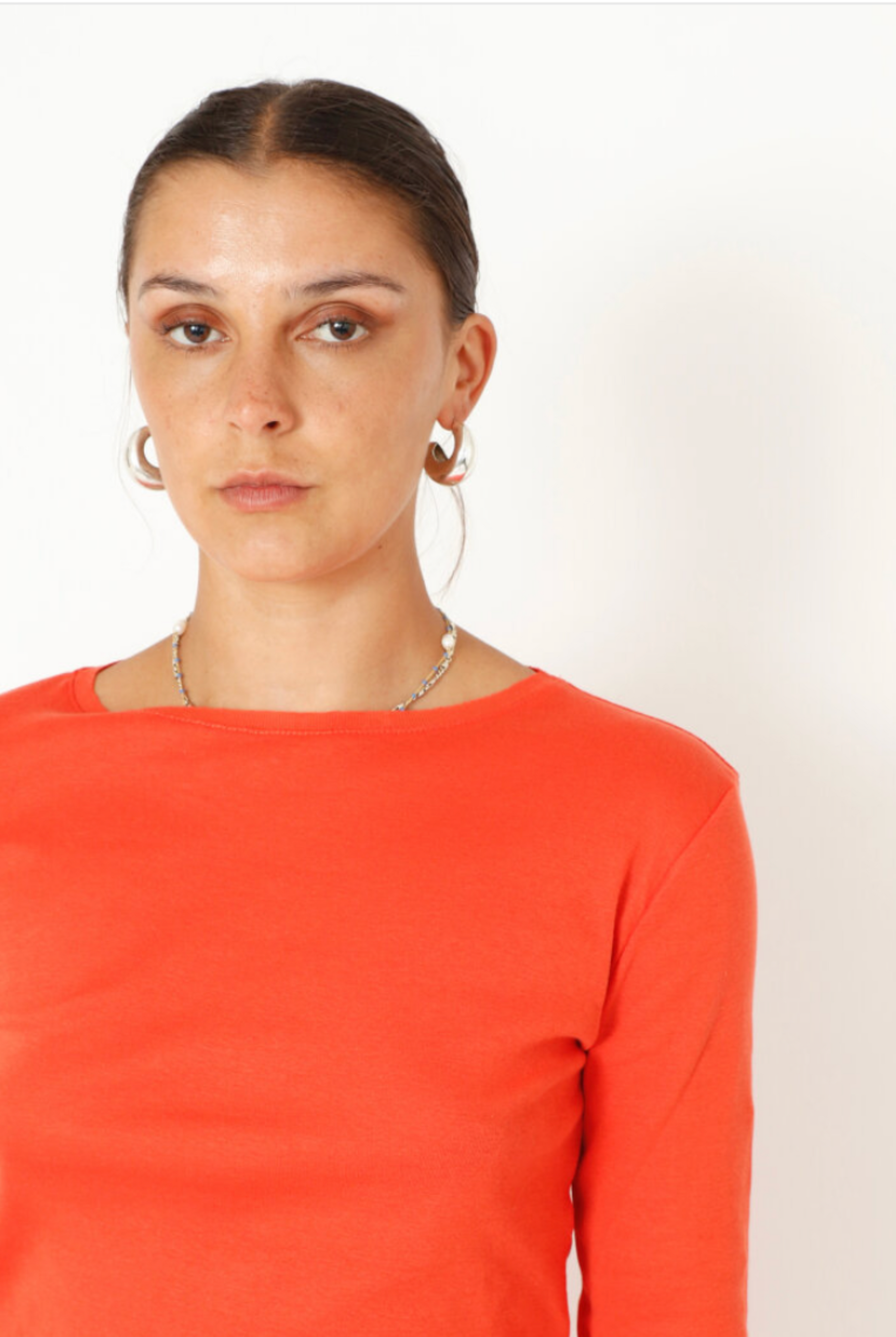 Women's soft, organic cotton long sleeve tee by Sort Aarhus. In colour Orange spritz. Close up view.